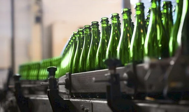 Green bottles on a factory conveyor belt