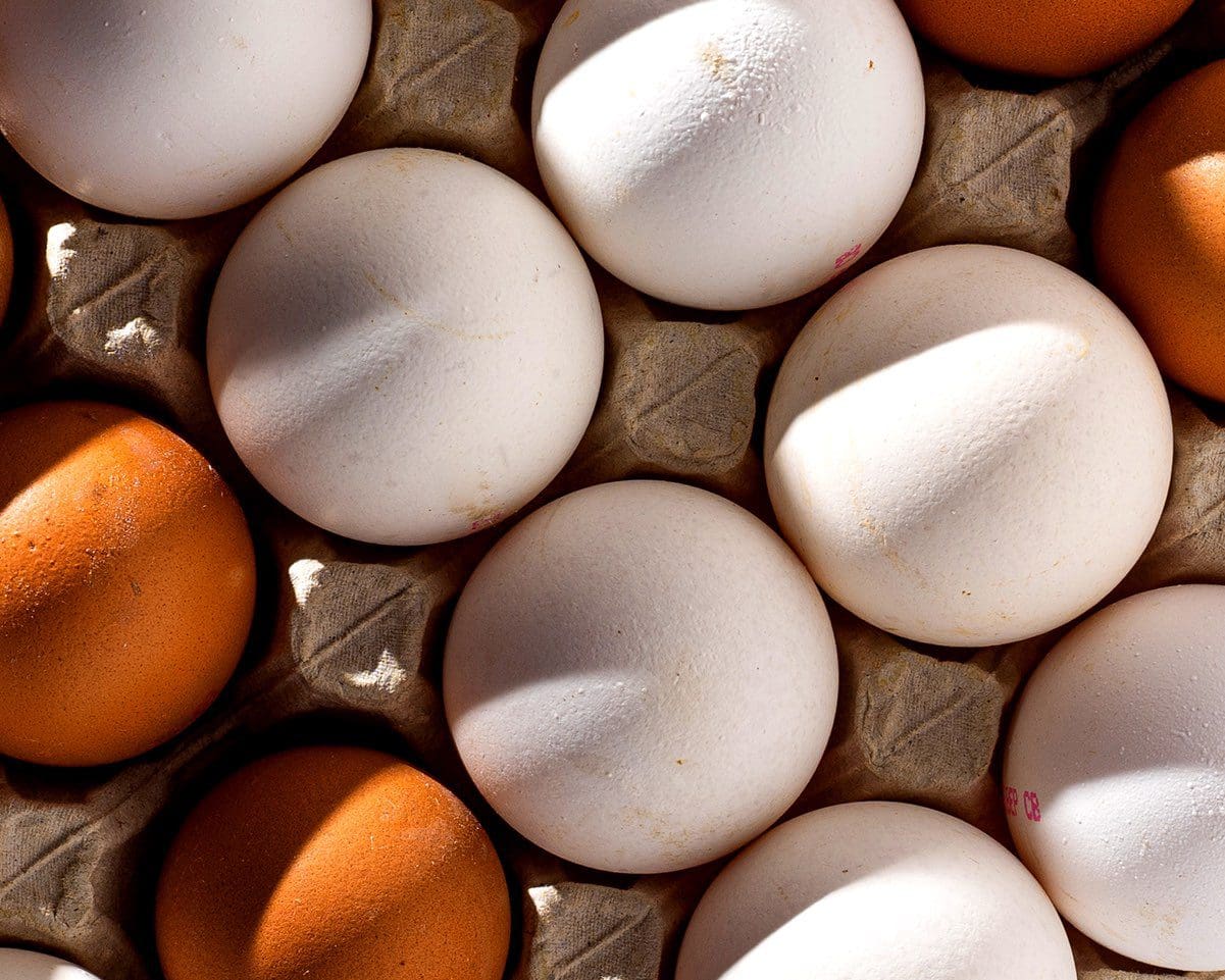 White and brown eggs in a paper box tray