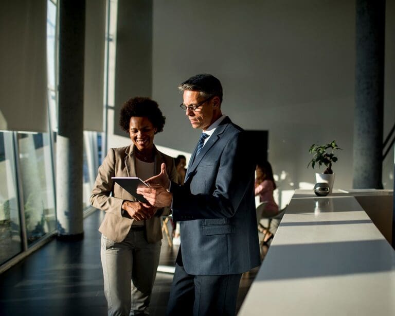 Business people using digital tablet while standing in the office