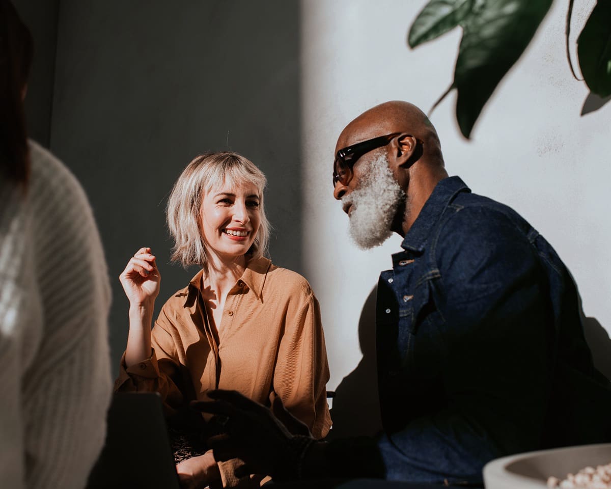 A man and woman sit beside each other in a sunny modern environment