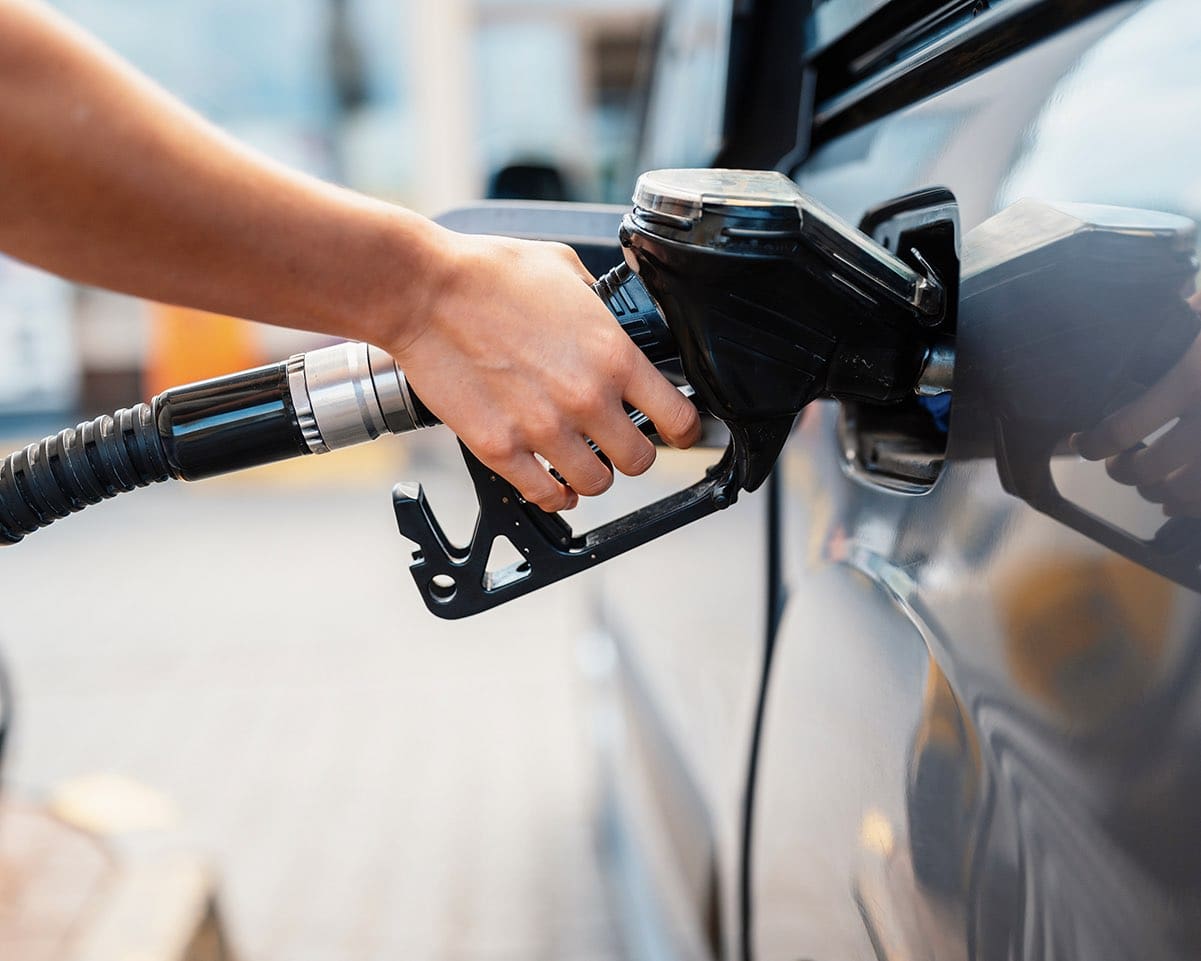 Closeup of a person pumping gasoline fuel in car at gas station