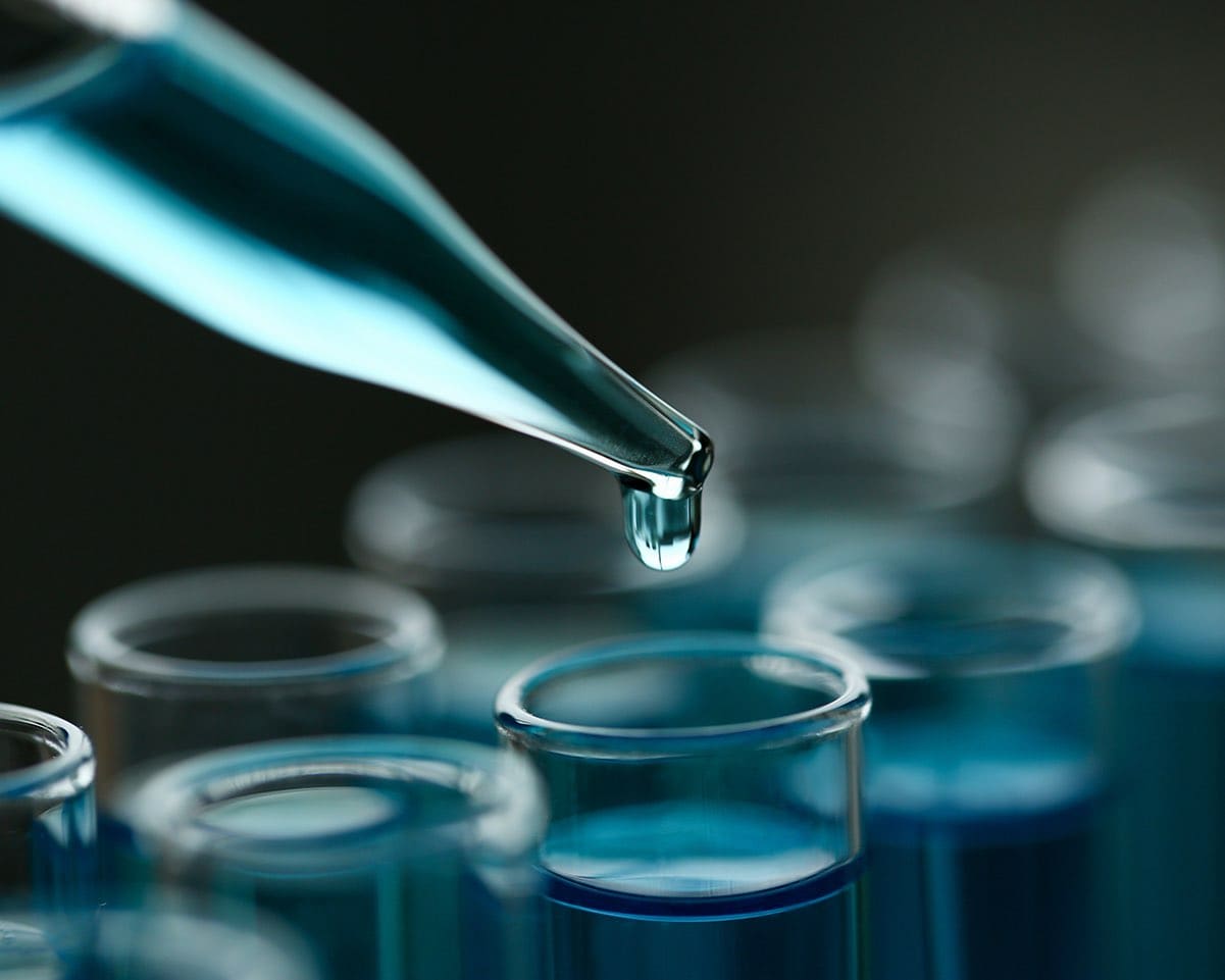 Glass test tube holding a light blue liquid