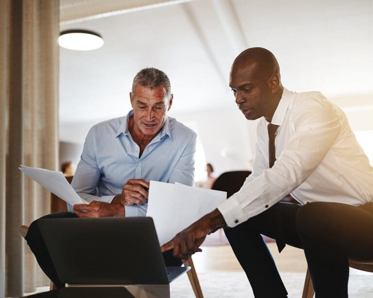 Two businessmen discussing work together in an office